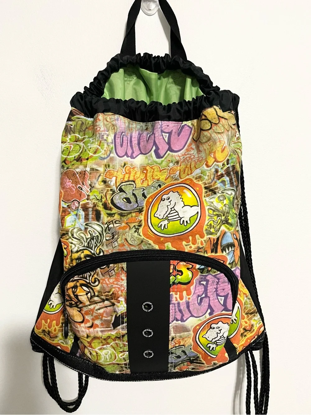 CROCS Graffiti Multicolor Print Cinch Drawstring Backpack. Front Zip Pocket